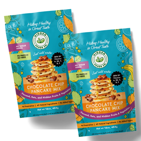 Two packages of Chocolate Chip Pancake Mix with illustrations of pancakes, chocolate chips, and fruits on the front. The packaging highlights no sugar added and high protein content.