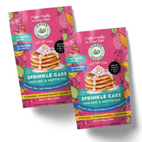 Packaging for Sprinkle Cake Pancake and Muffin Mix showing the product name and images of pancakes with sprinkles on top. The package highlights no sugar added and high protein content.